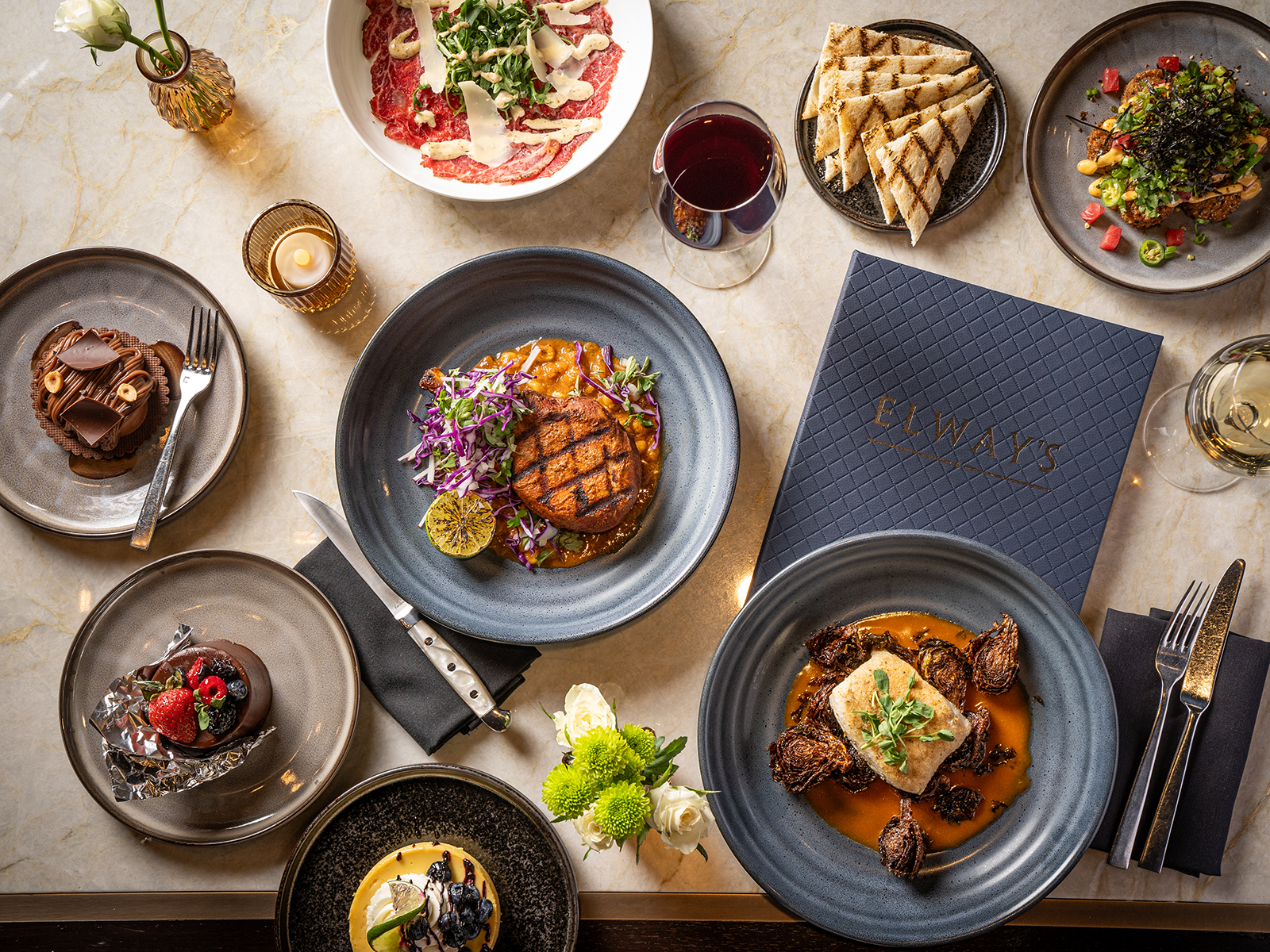 A spread of steak, sides and drinks at Elway's in downtown Denver
