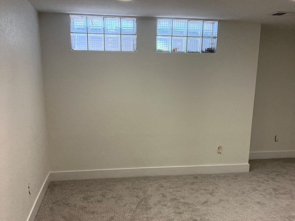 All-white basement with two narrow windows