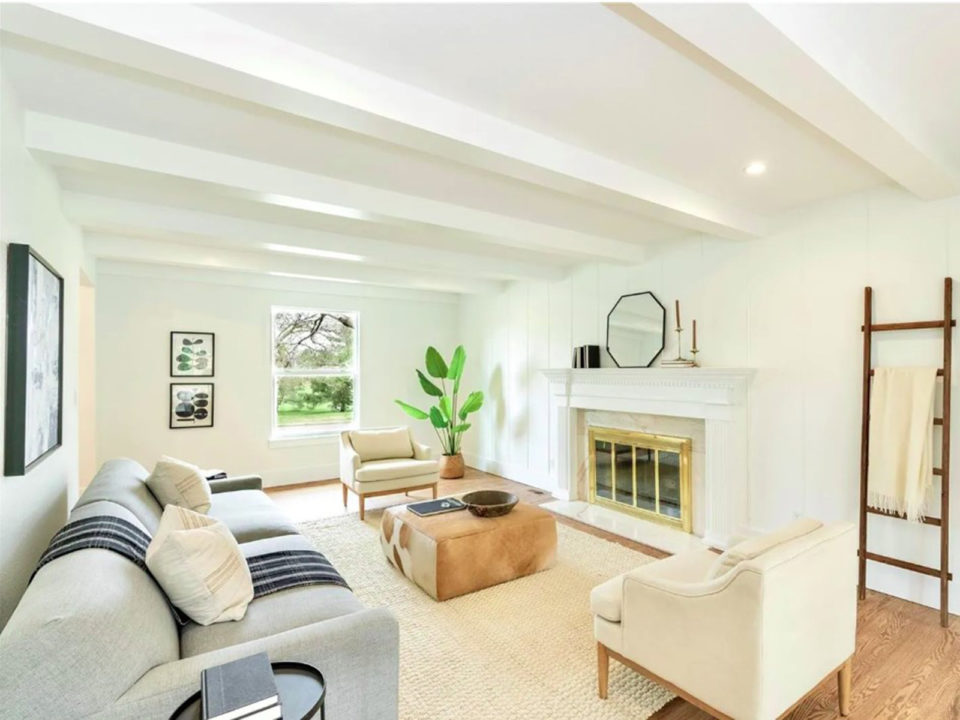 All-white living room with a fireplace and neutral furniture