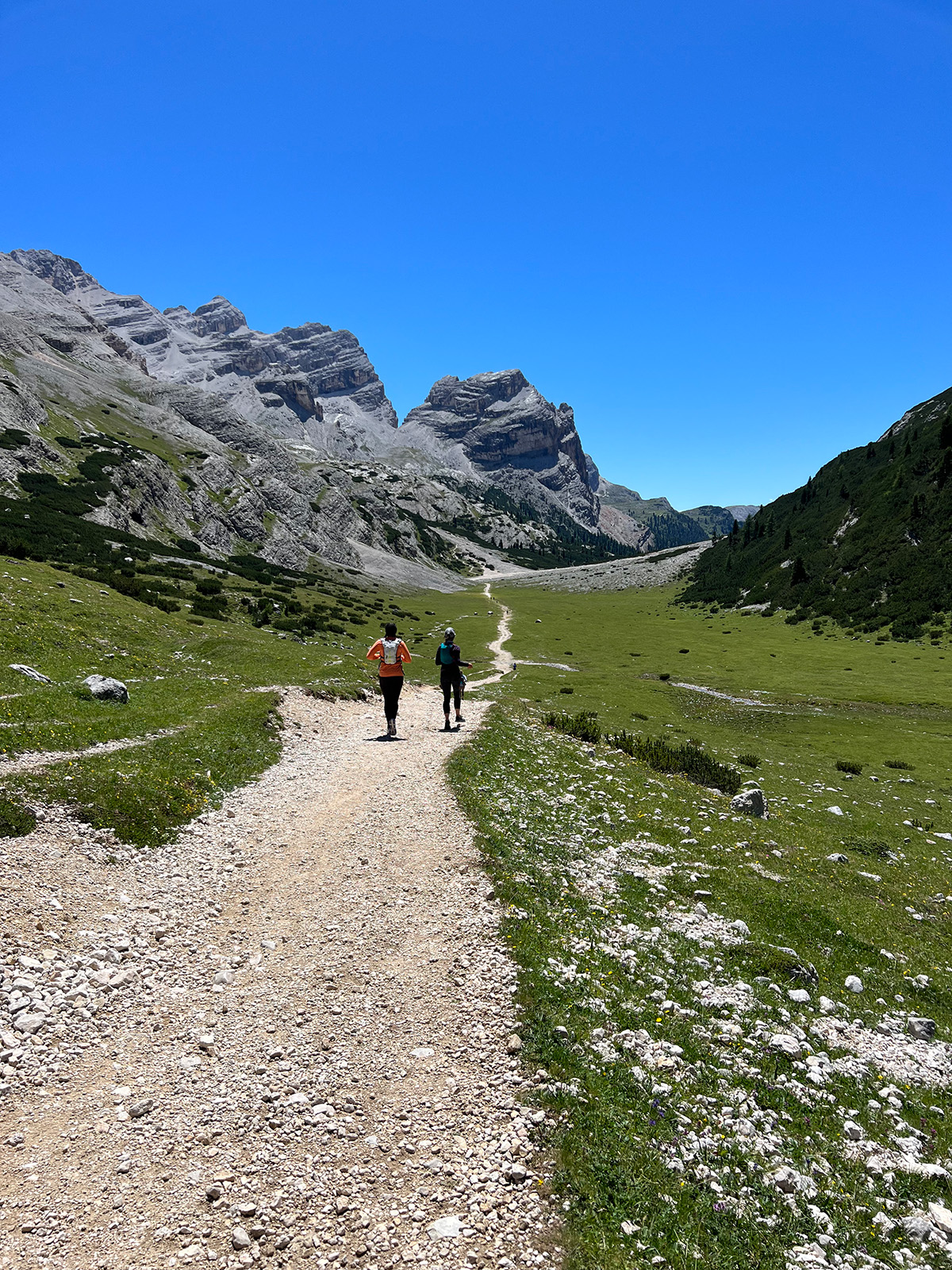 Two women running a trail in the Italian Dolomites