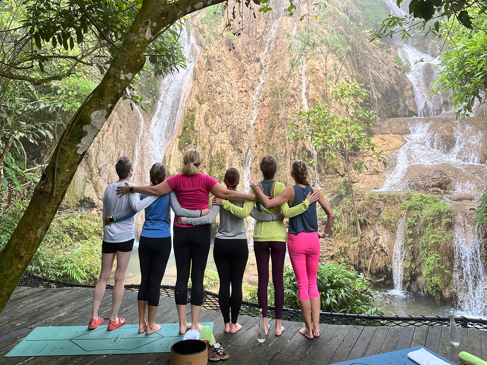 Women stand in a line with their backs to the camera on a yoga mat in Vietnam