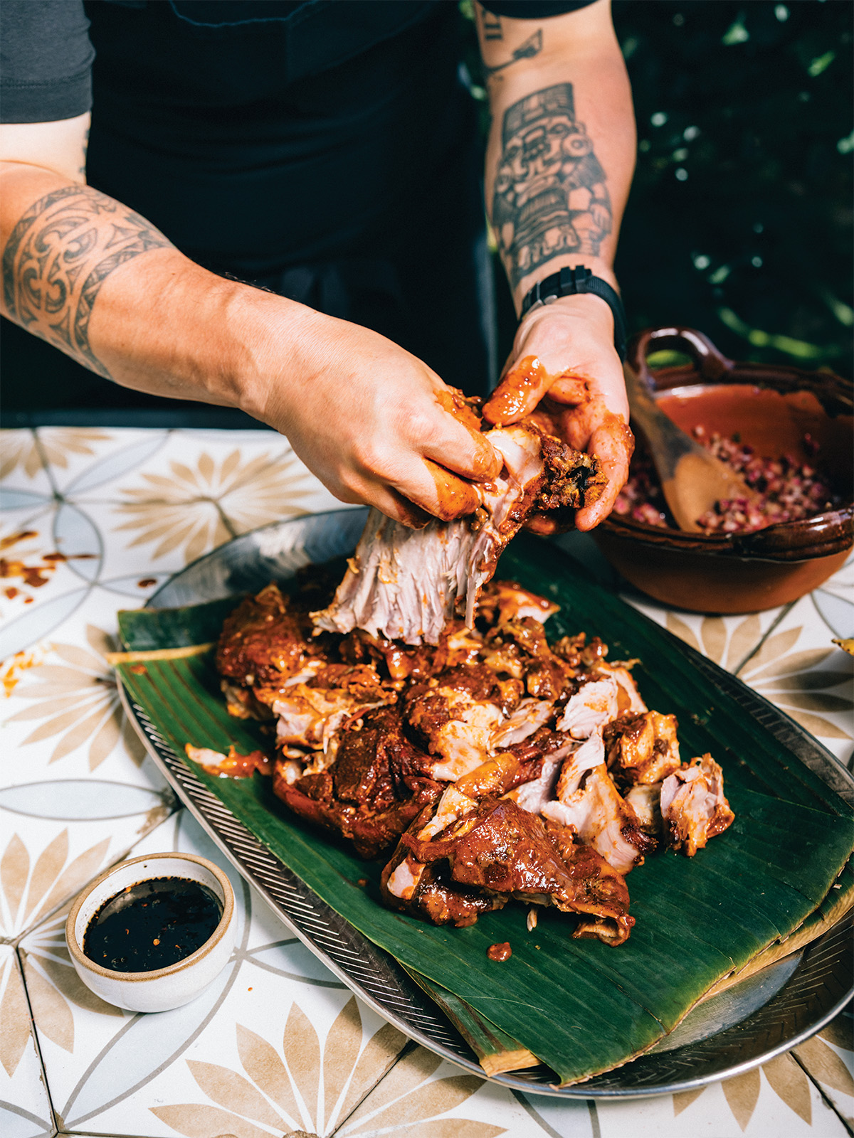 A man shredding pork by hand