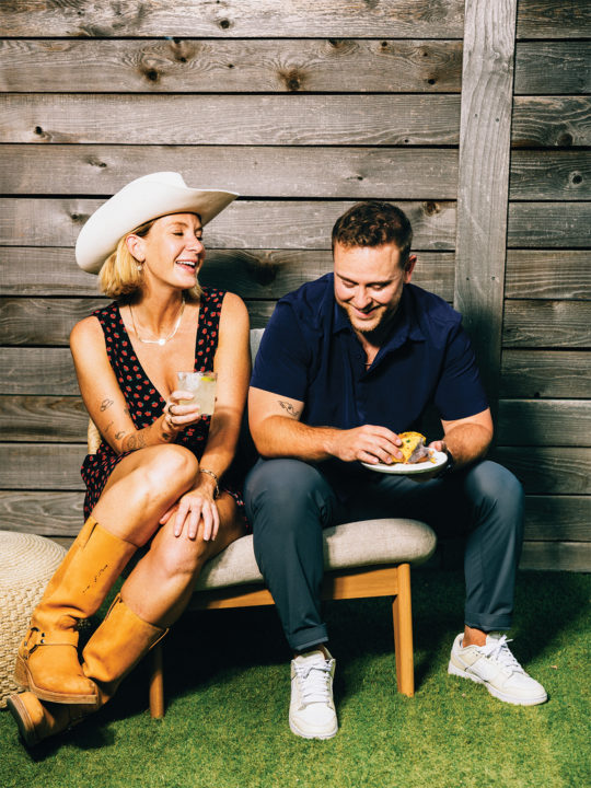 A woman and a man eating tacos