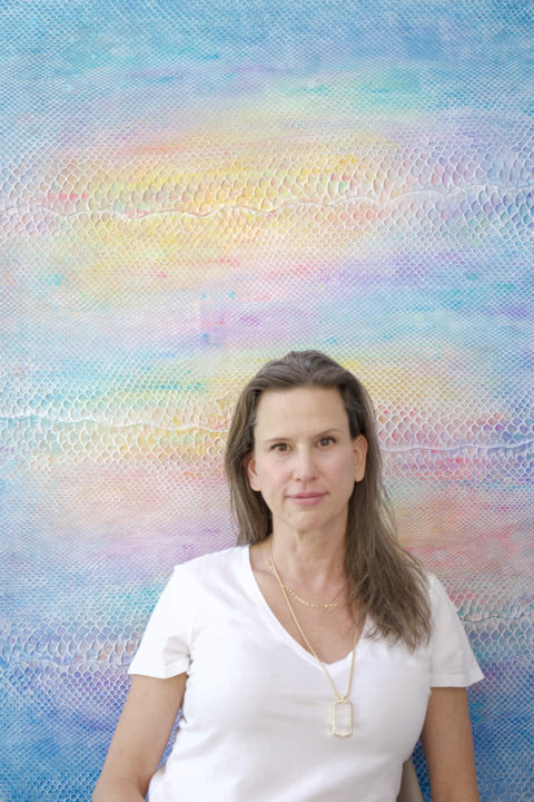 Laura Shape poses in front of her painting on python skin titled "Beautiful Stranger"
