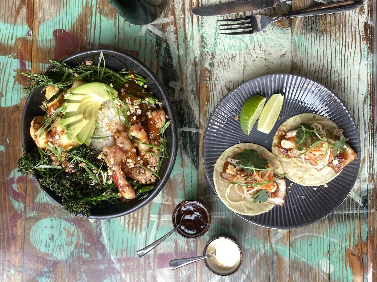 A Buddha bowl and plate of tacos on a table