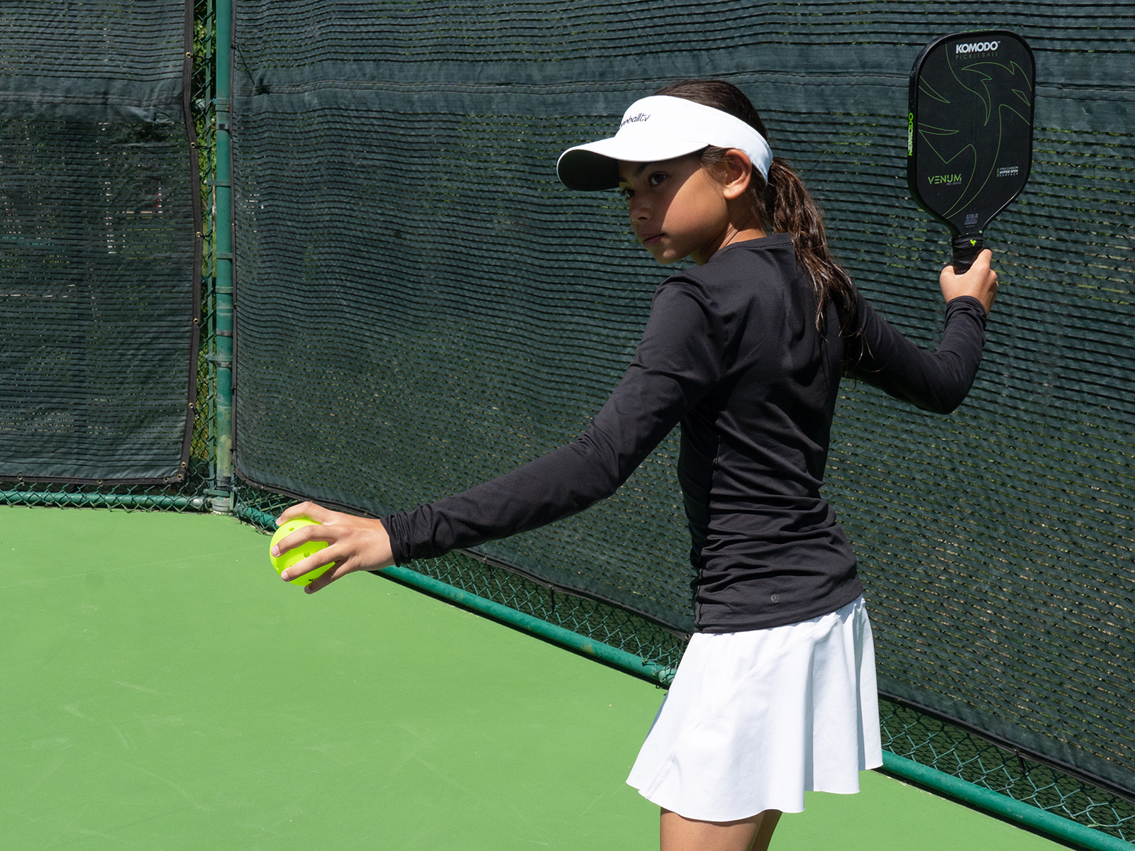 Young girl prepares to serve a pickleball