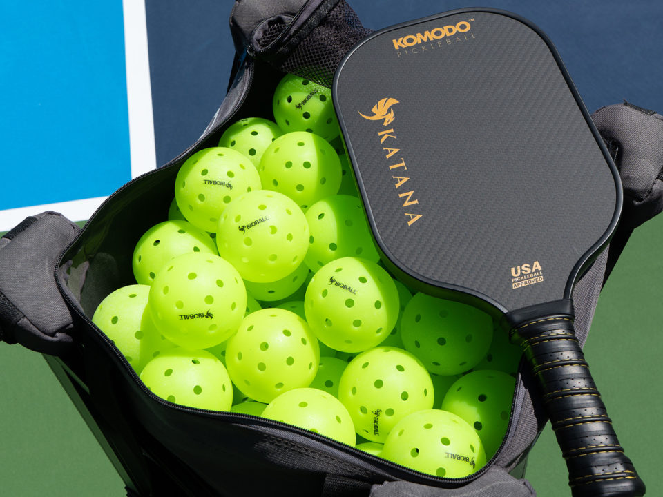 A bag of pickleballs and a paddle