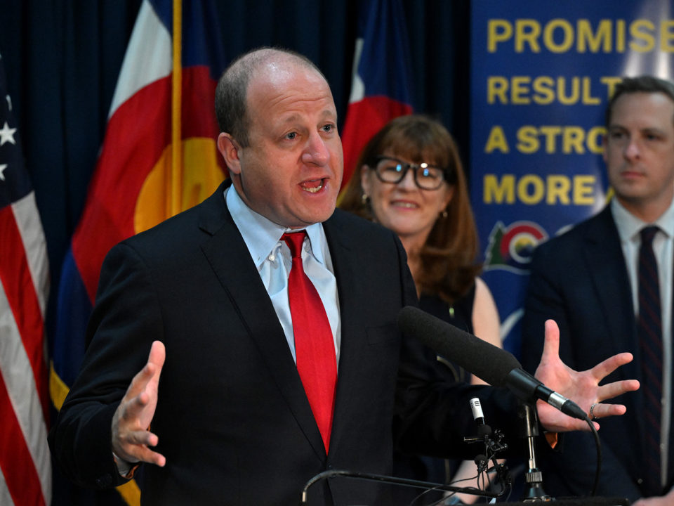 Governor Jared Polis speaks at a podium