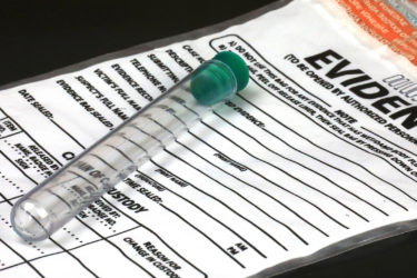 A test tube sits on top of an evidence bag
