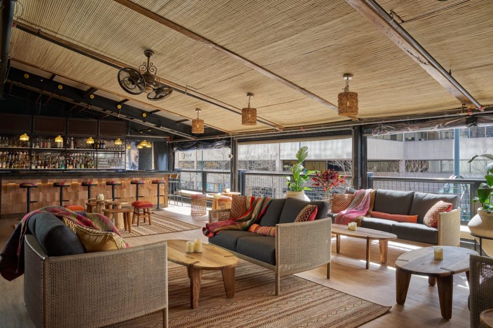 Lounge-style outdoor furniture on a covered restaurant rooftop patio.