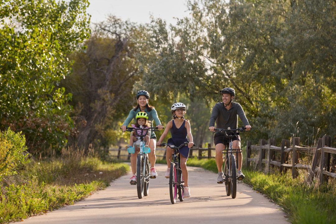 A family of four bikes along the Poudre River Trail.