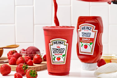 red smoothie pours out of a blender into a cup