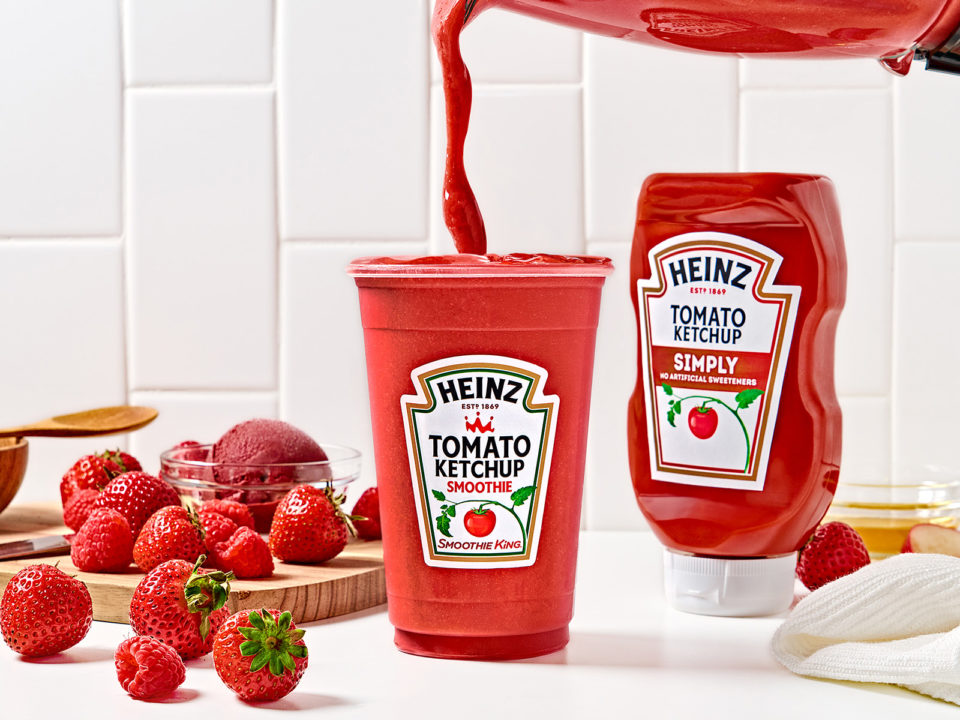 red smoothie pours out of a blender into a cup