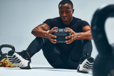 Man sits on the floor holding the ROCC in his hands