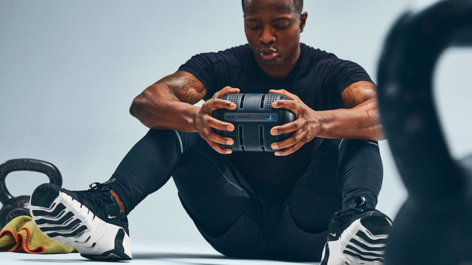 Man sits on the floor holding the ROCC in his hands