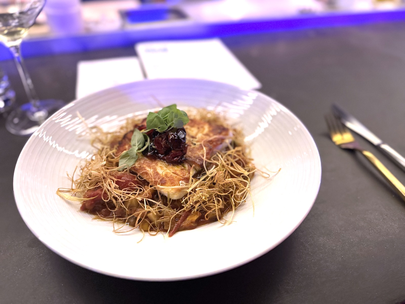 Grilled halibut on eggplant with fried haystack onions