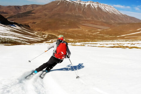 A screen grab of a man ripping down a snowy slope in Africa on skis from Big Mountain Soul: Ski Africa