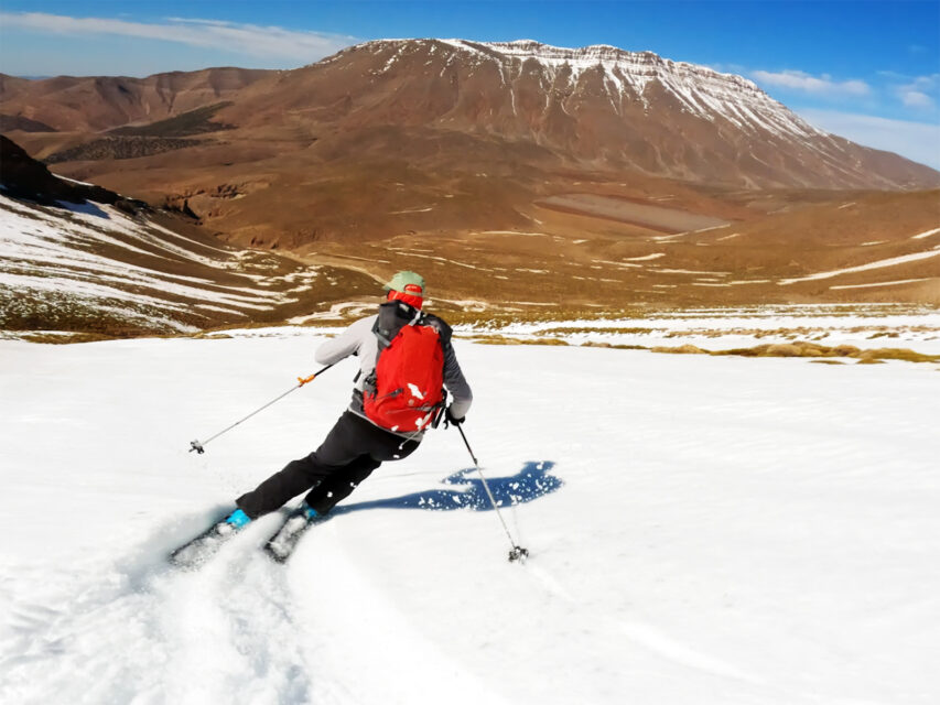 A screen grab of a man ripping down a snowy slope in Africa on skis from Big Mountain Soul: Ski Africa