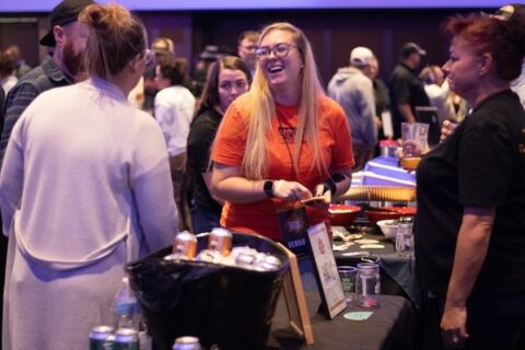 Three women standing around a table for a tasting.