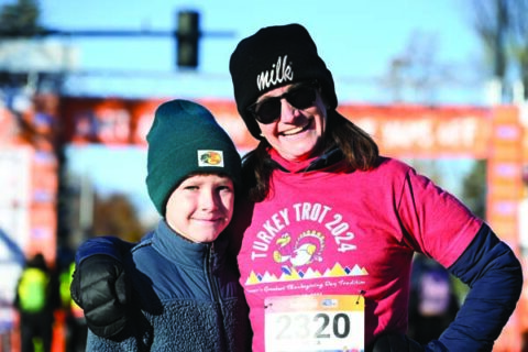 A woman and a child posing together at a finish line.