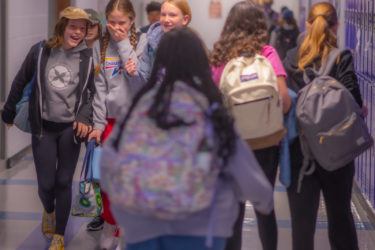 middle school girls giggle in the hallway