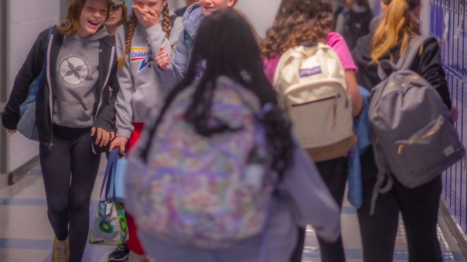 middle school girls giggle in the hallway