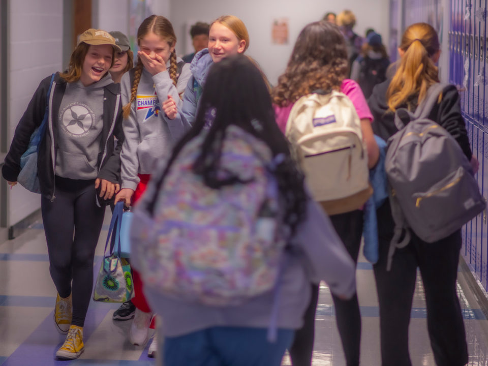 middle school girls giggle in the hallway