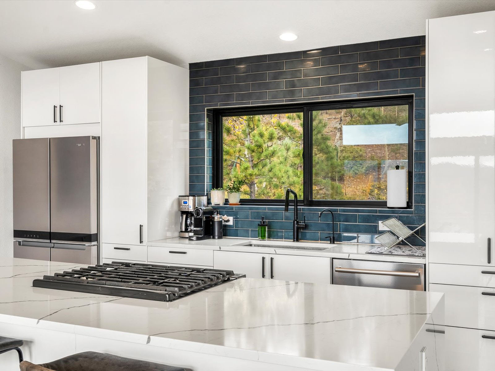 Kitchen with a large window and blue backsplash
