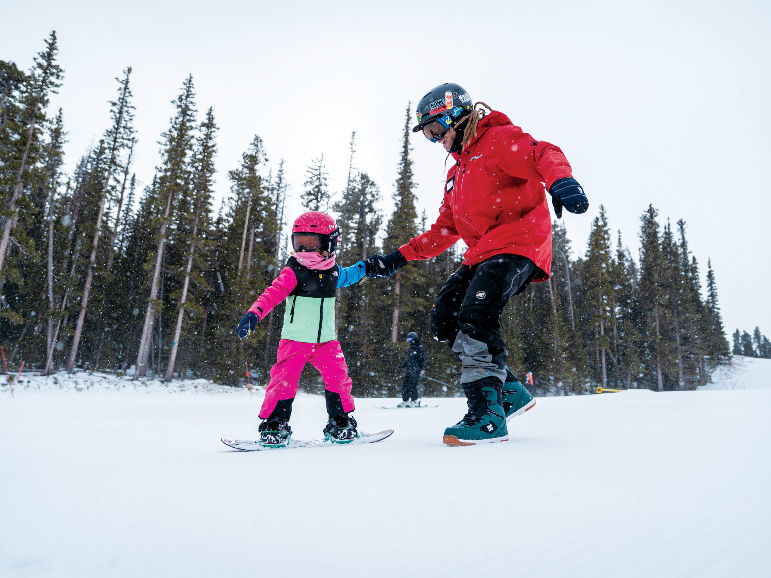A snowboard instructor helps teach a child at Eldora Mountain Resort in Colorado