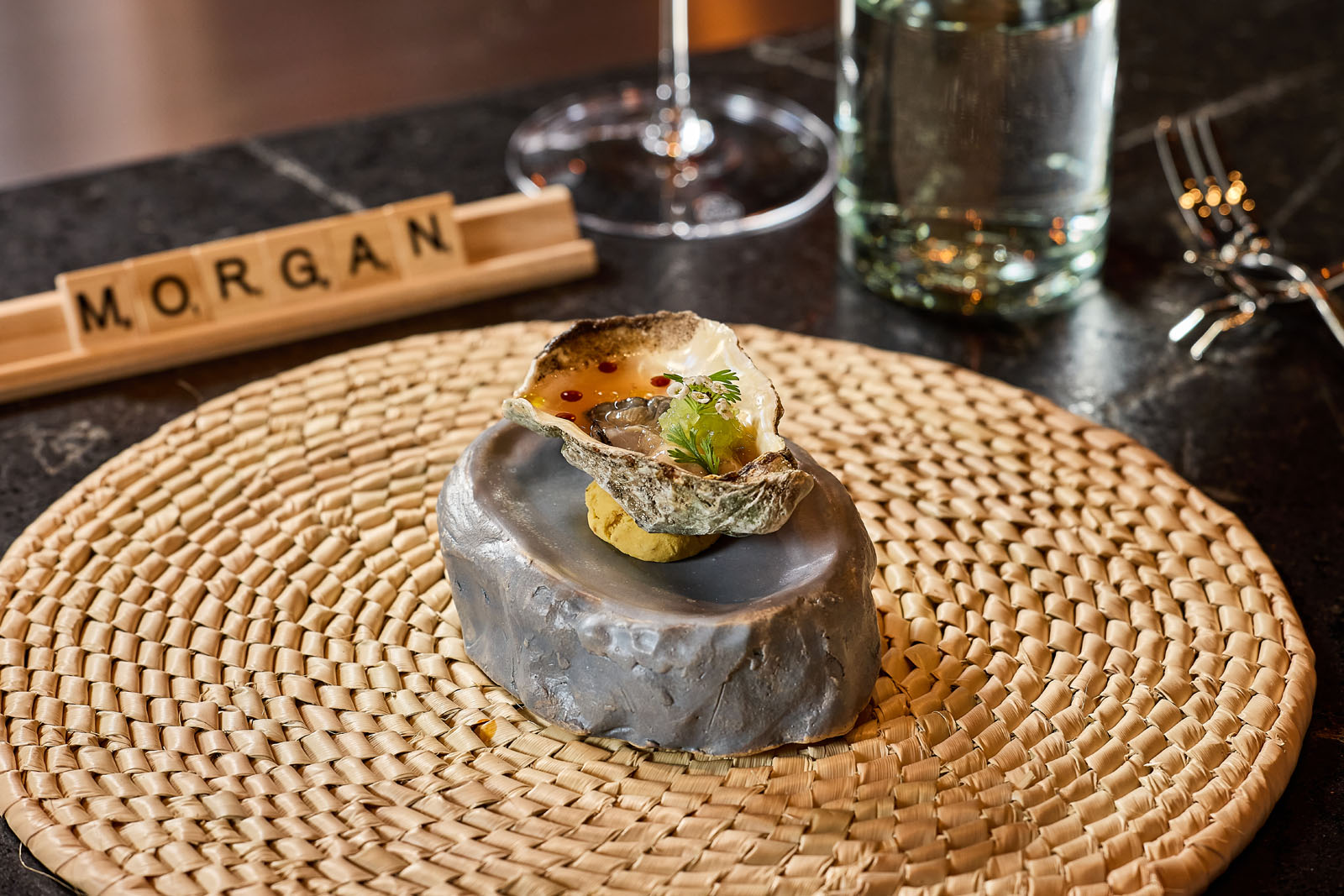 Ostione served on a stone on top of a rattan placemat