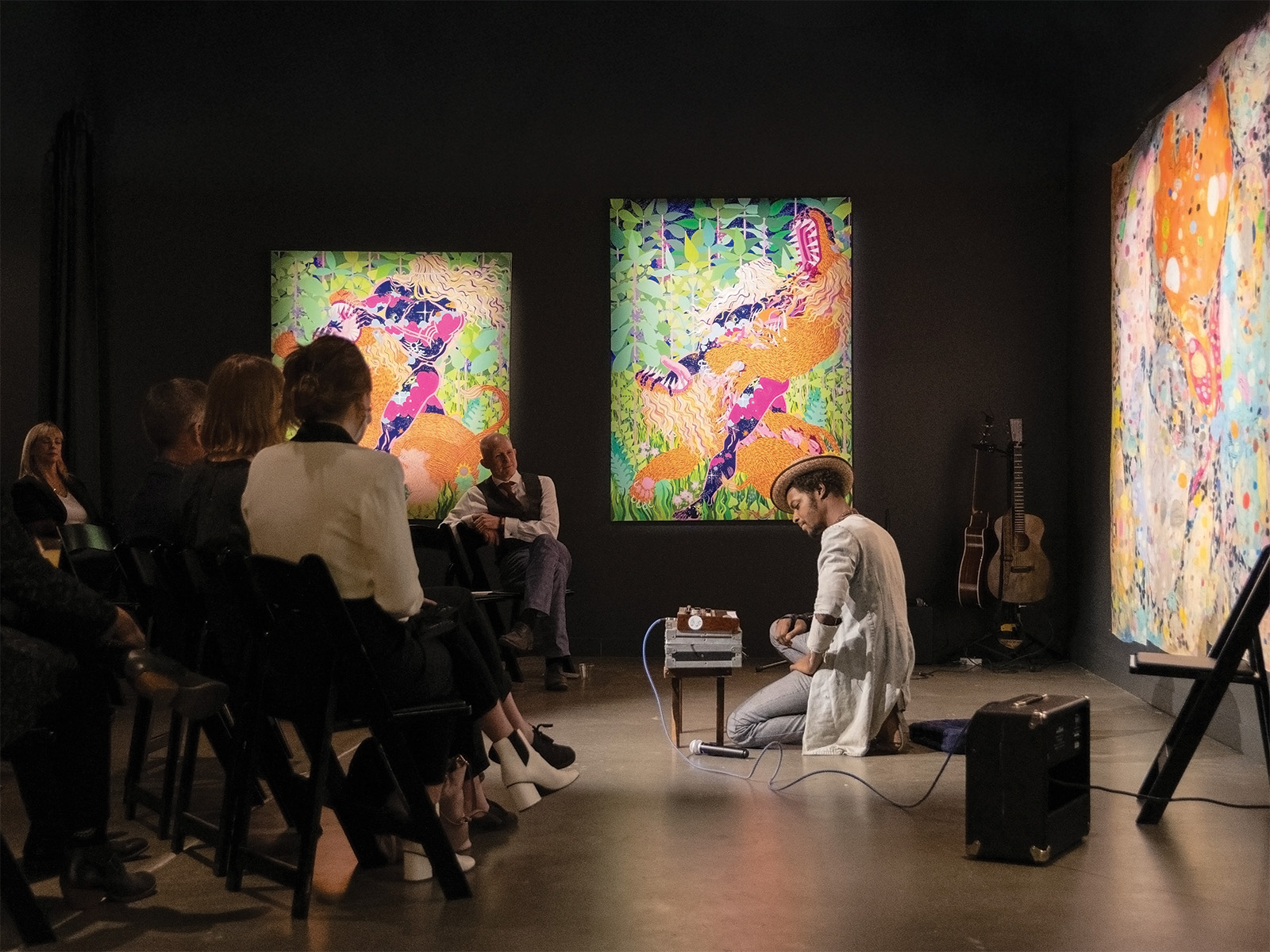 A man performs in front of artwork
