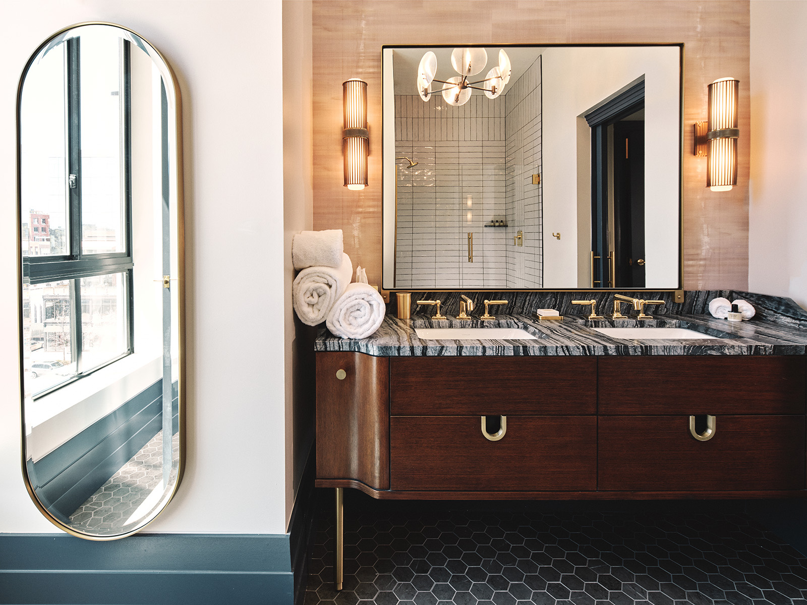 Upscale hotel bathroom with double vanity and walk-in shower