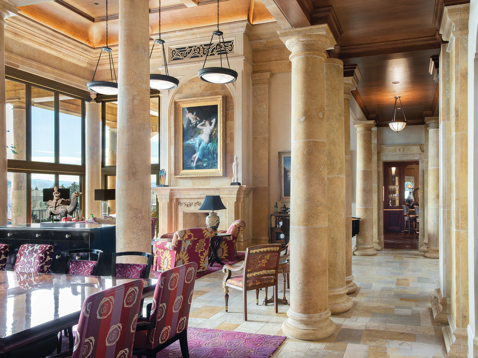 Dining room and living room with neoclassical columns and framed art over the fireplace