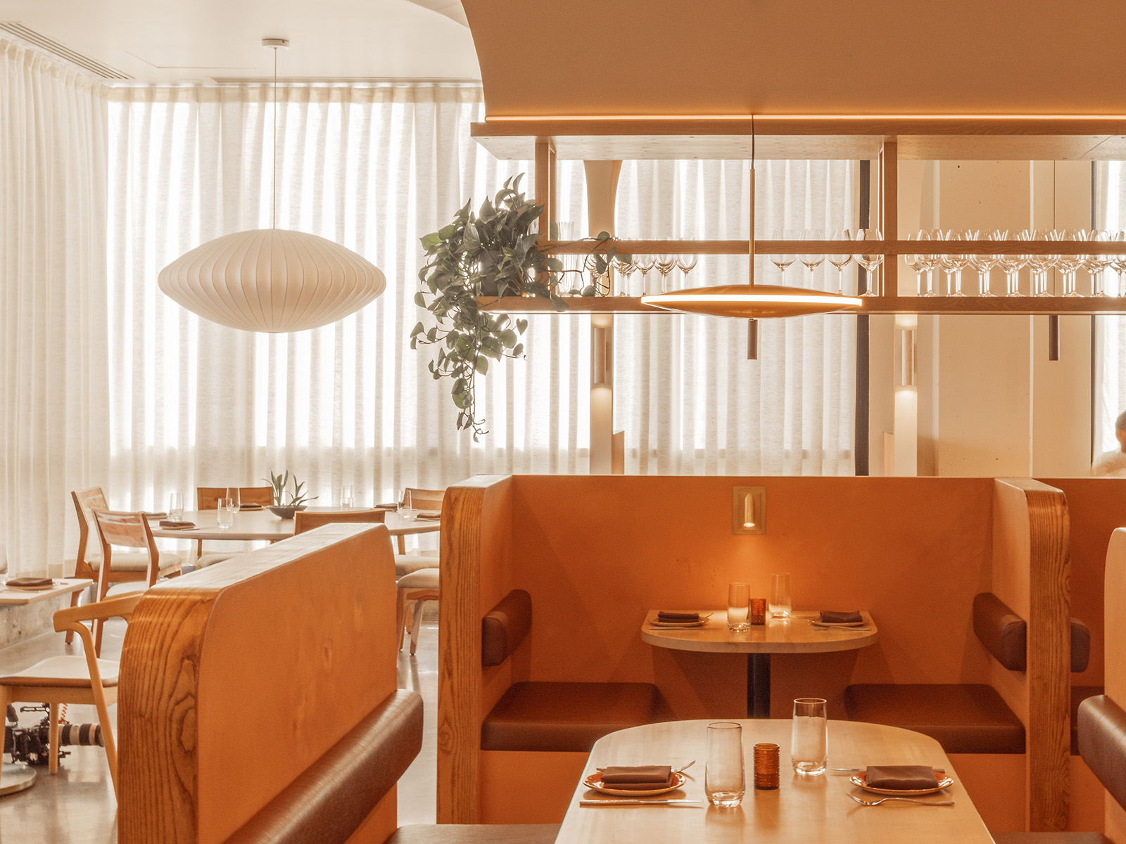 Dear Emilia dining room with arched booths and oval pendant lighting