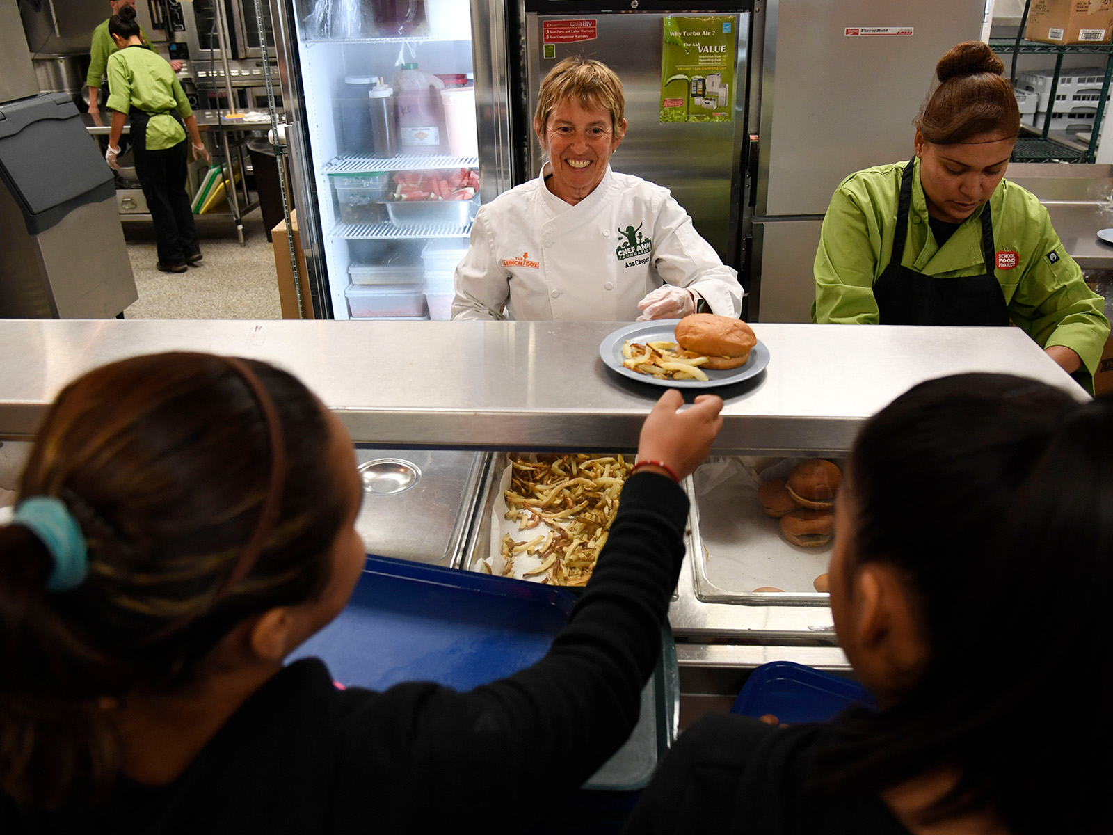 Woman serving students lunch at school