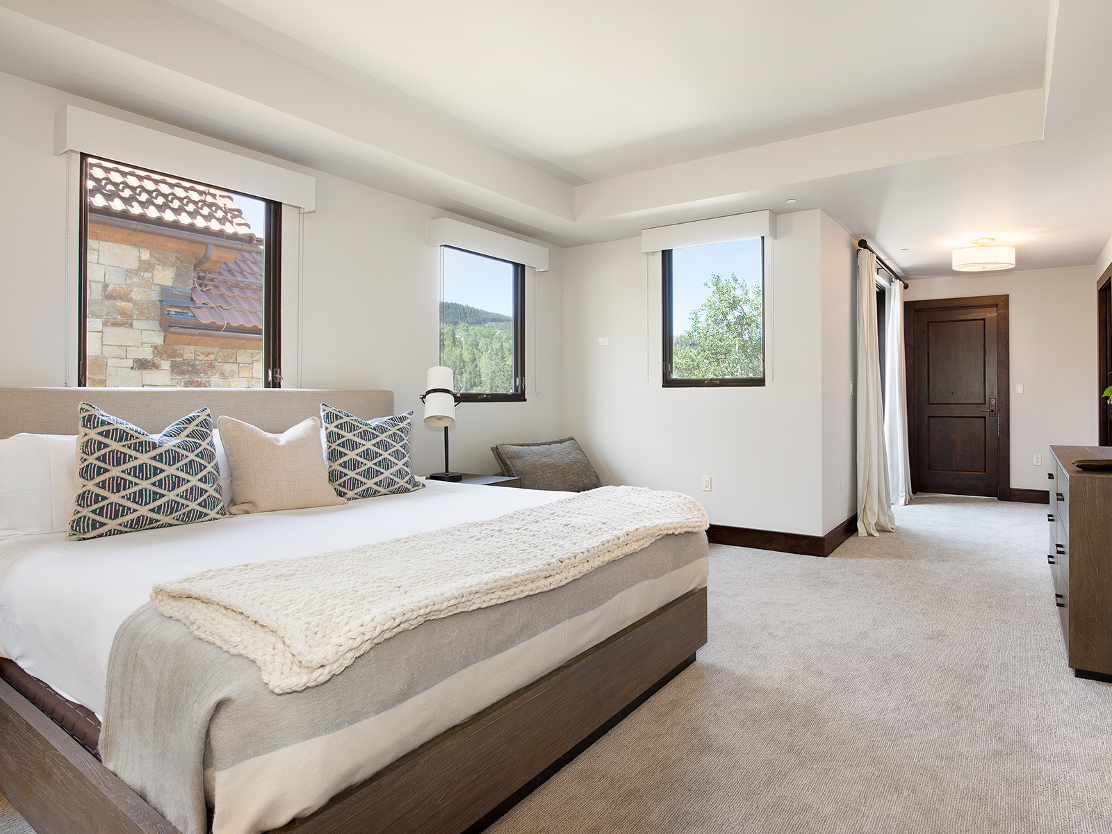 White bedroom with three large windows