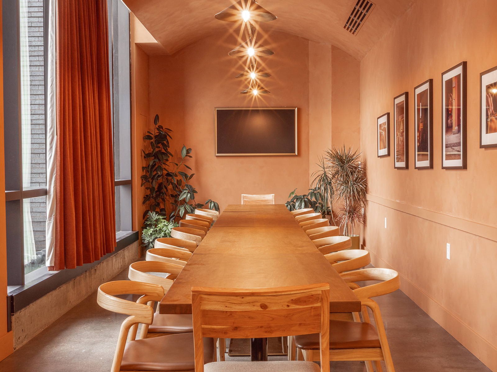 Private dining room with earthy orange walls and a long wood table