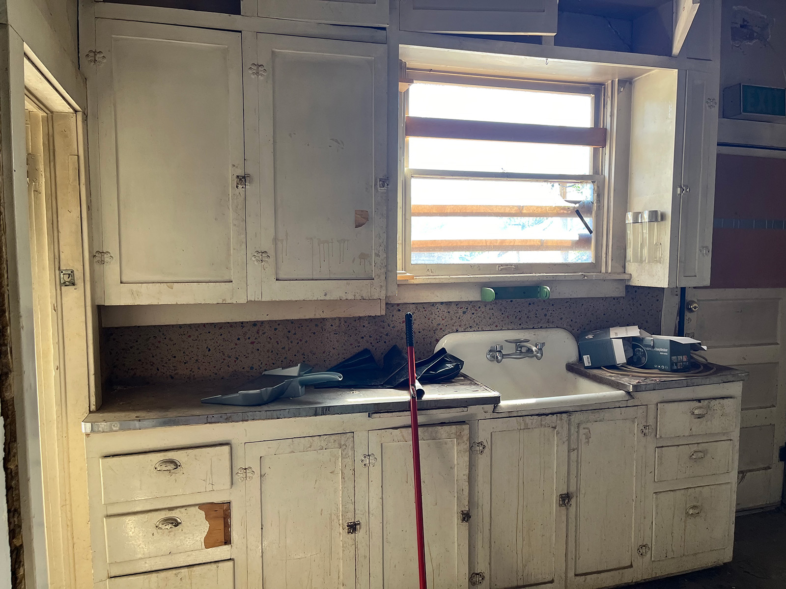 Old kitchen with dirty white cabinets