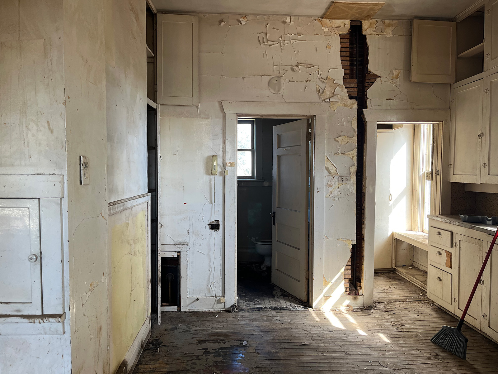 Old dirty kitchen with peeling white walls