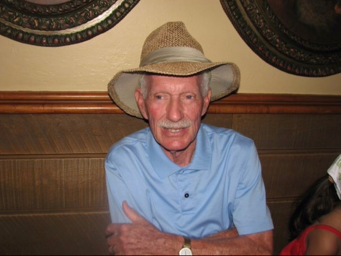 A man in a blue shirt and Western hat