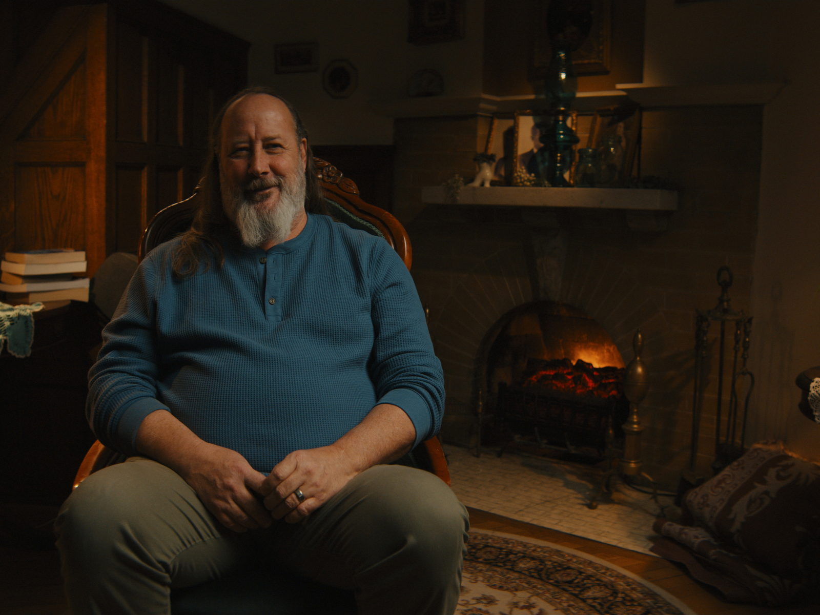 A man in a blue shirt sitting for an interview