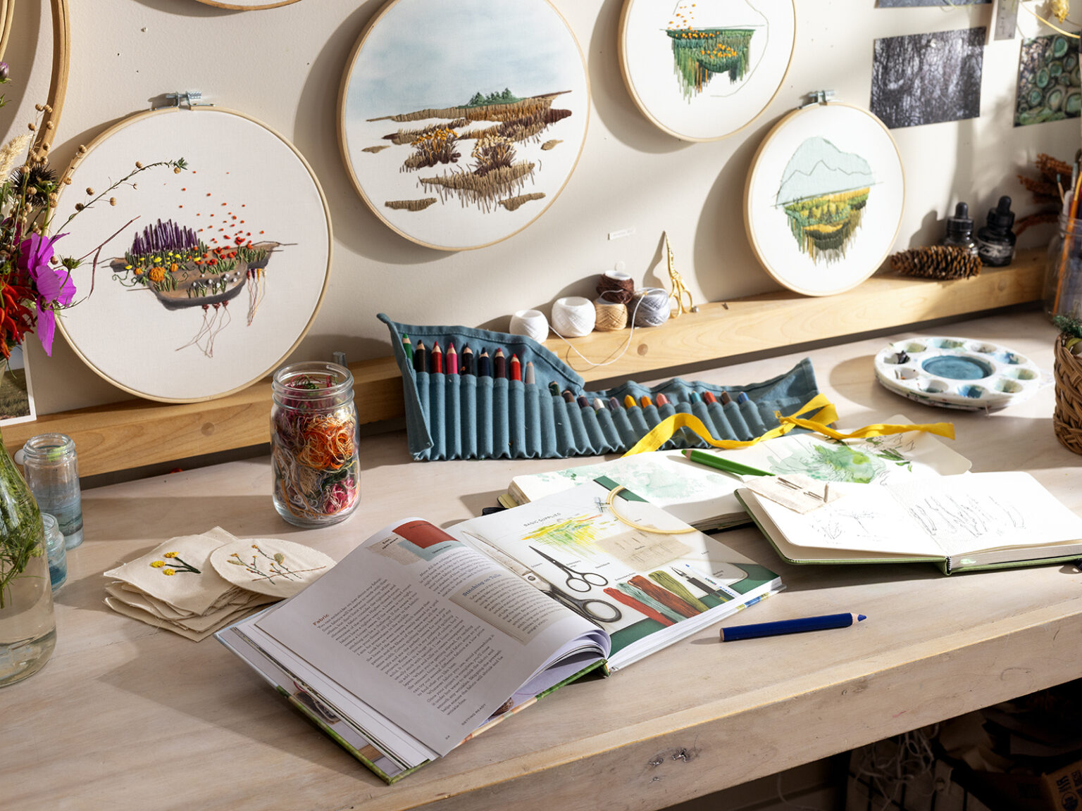 Various art supplies and embroidery supples on a work table