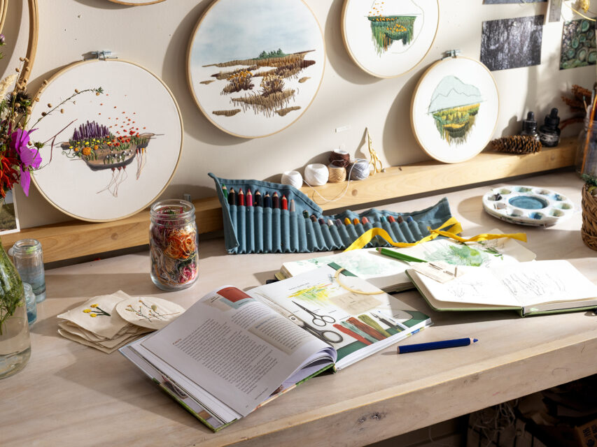 Various art supplies and embroidery supples on a work table