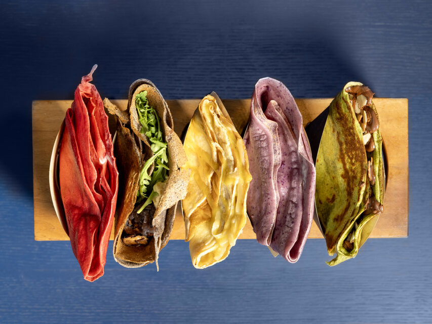 Red, brown, yellow, purple, and green crepes, shot overhead