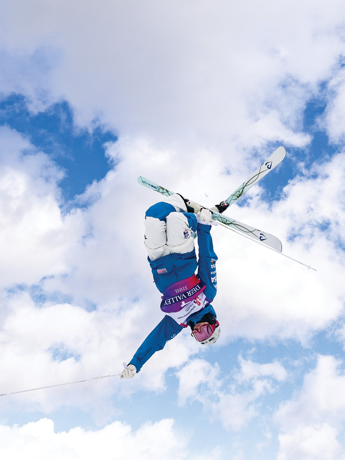 Jaelin Kauf throws a trick on skis; she’s upside down in the air and crossing her skis