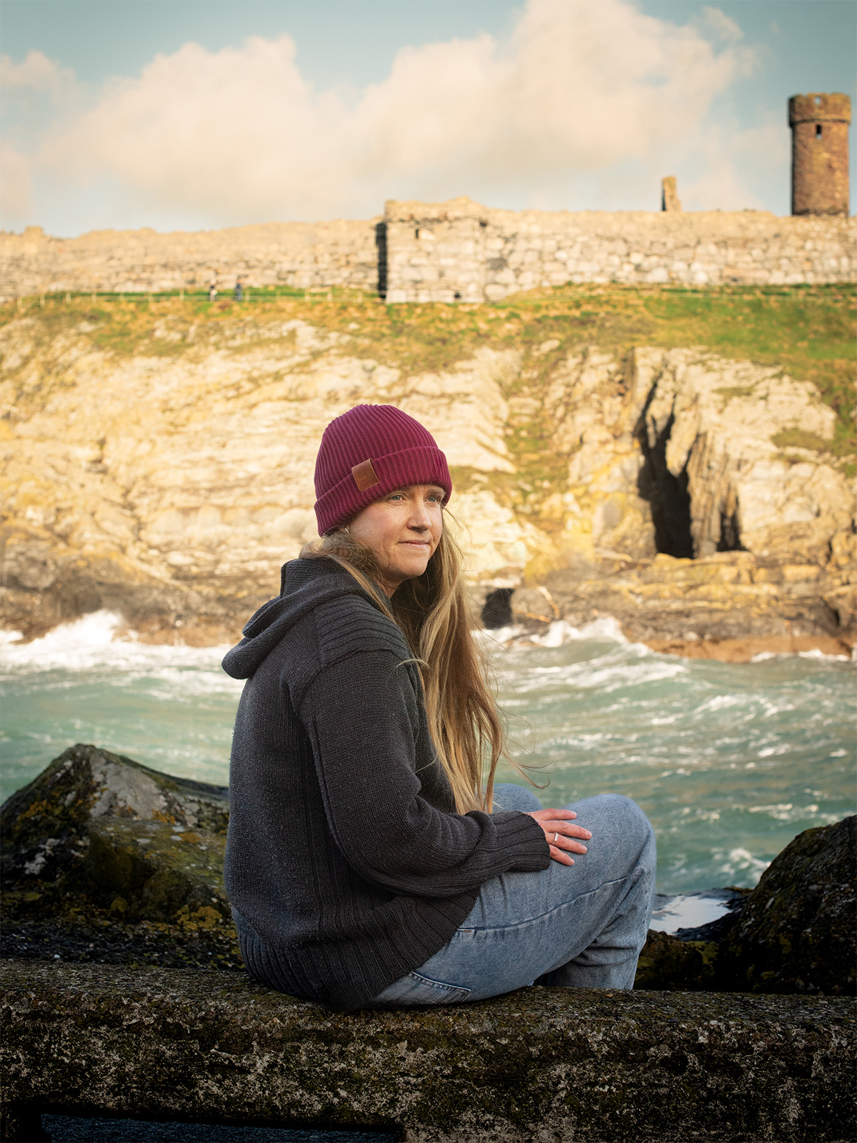Courtney Pollock sits on a rock beside rushing water