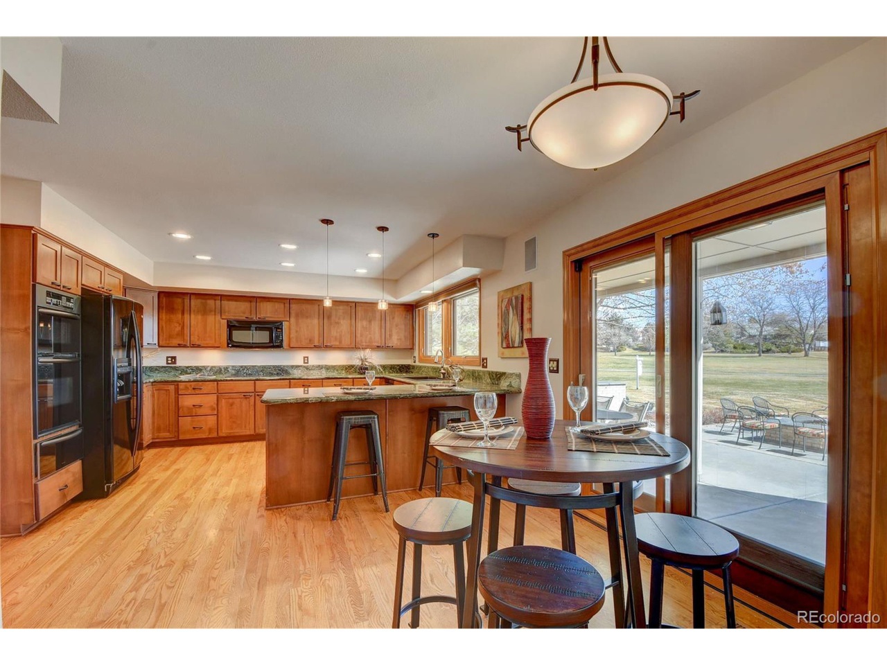 Wood kitchen with dated light fixtures and barstools