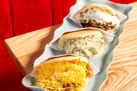 Three arepas on a white platter