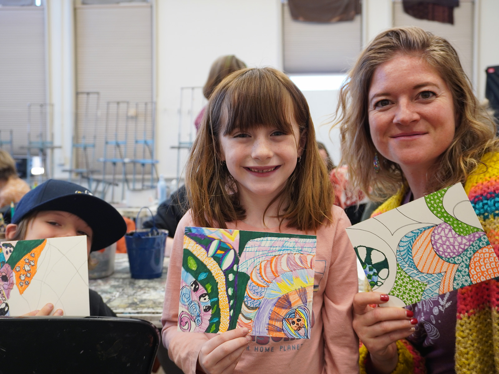 Three people showing artwork