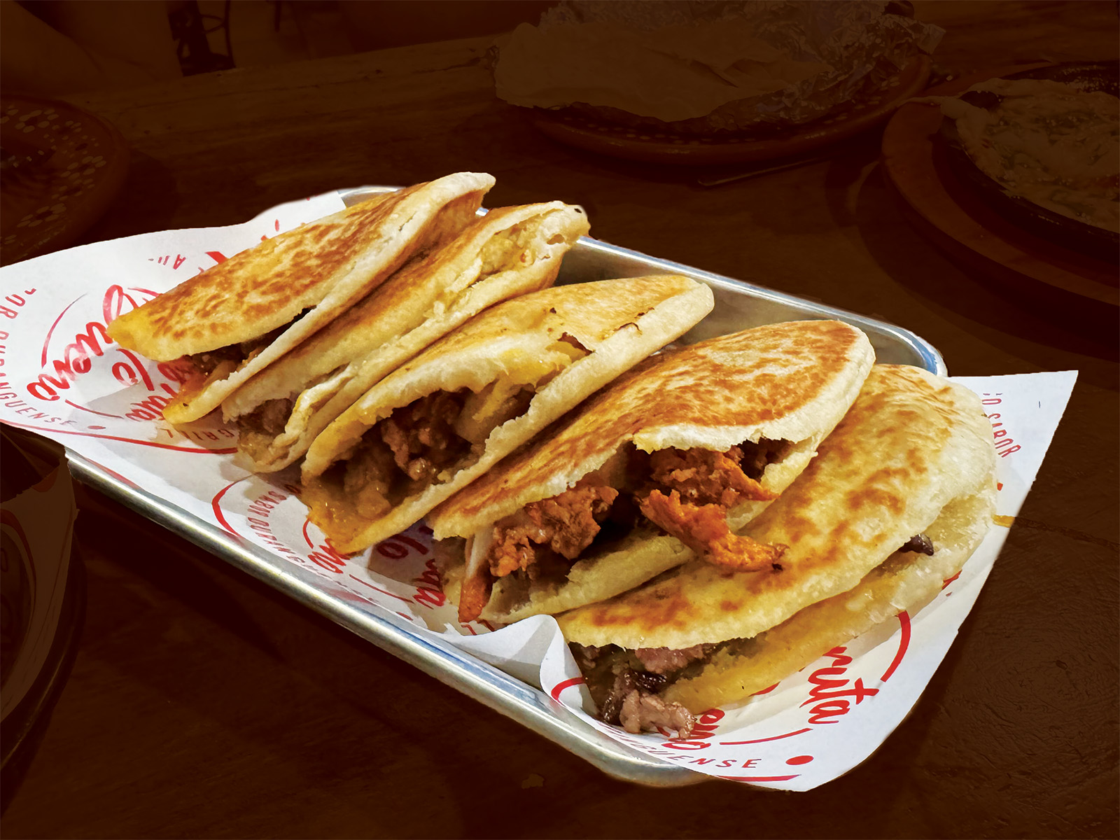 Five gorditas on a plate with white paper